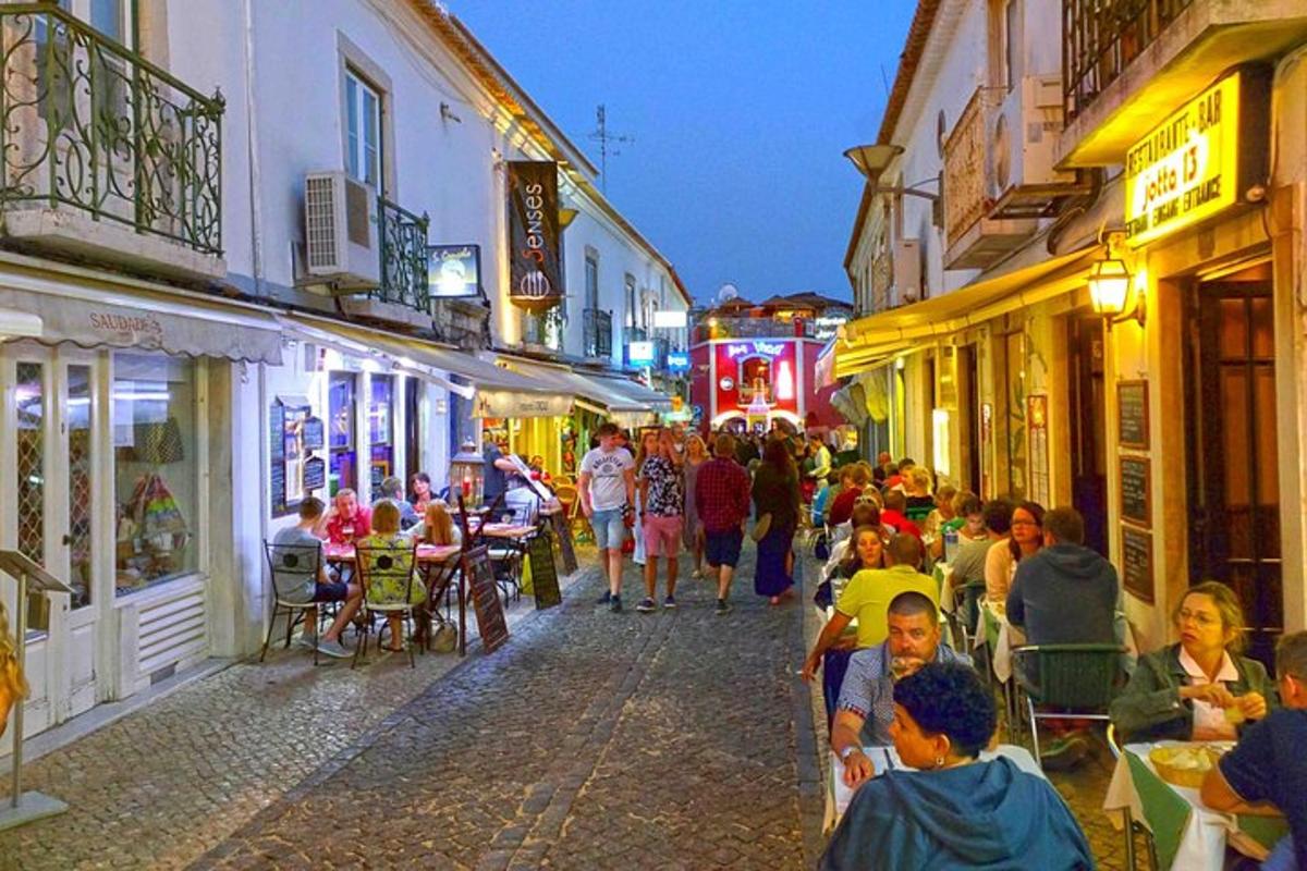 una multitud de personas caminando por una calle de noche