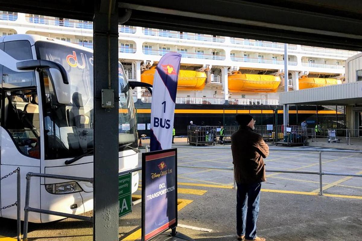 en mann som står på et busstopp ved siden av en buss