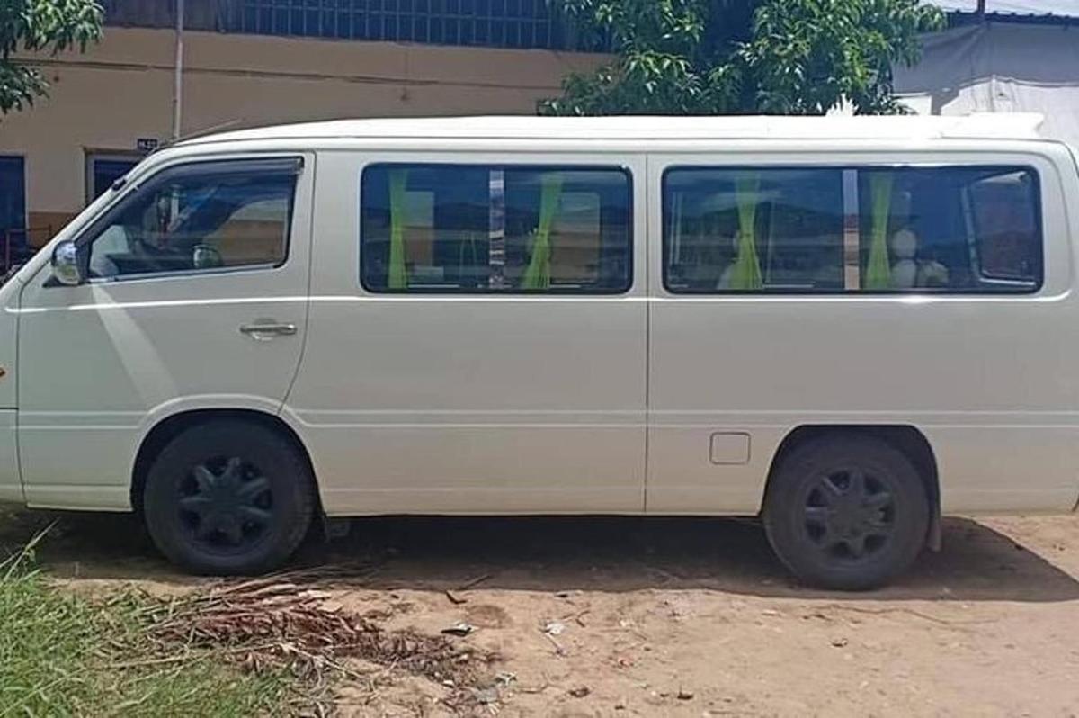 uma van branca estacionada em frente a um prédio