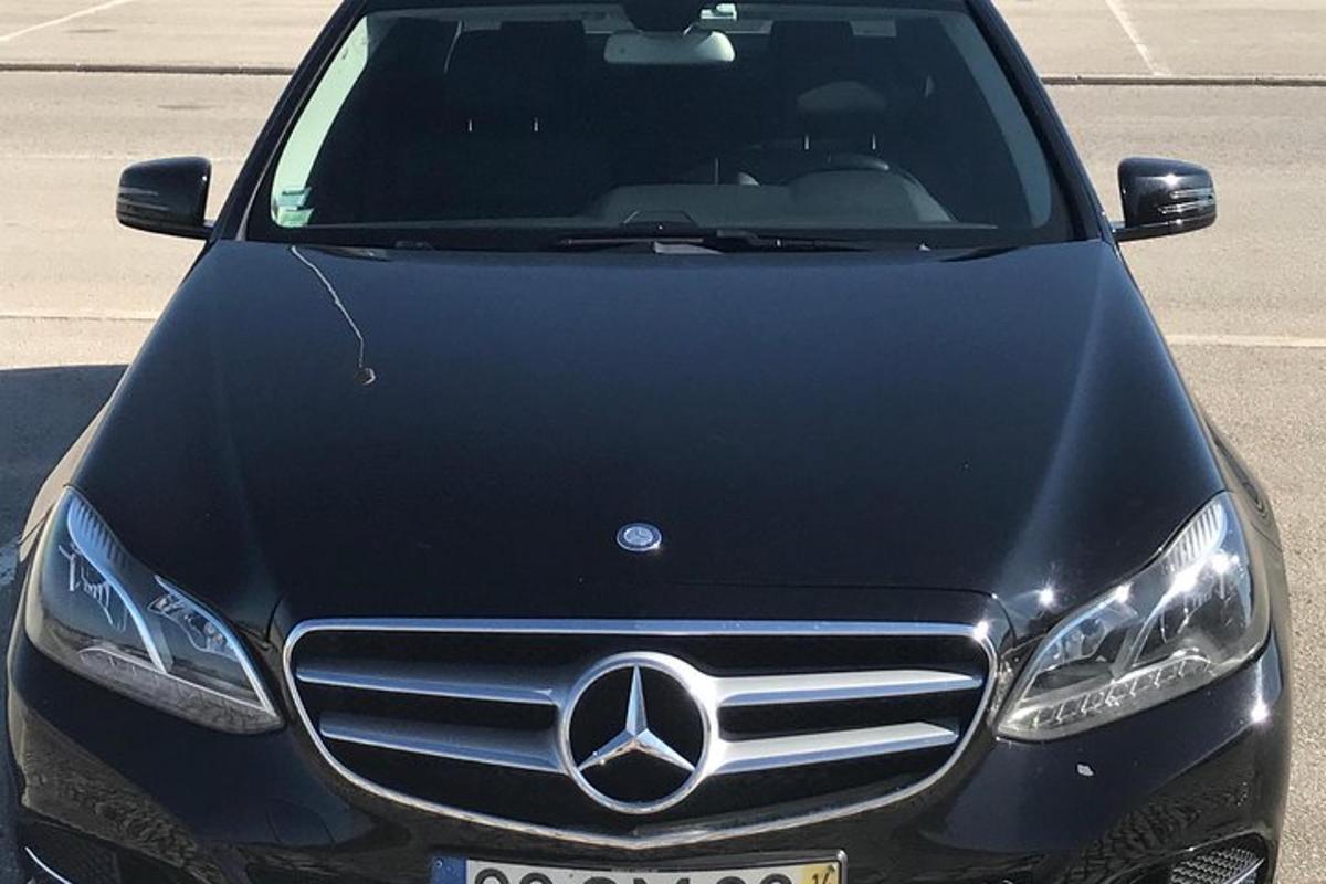 sebuah kereta mercedes benz hitam diletakkan di tempat letak kereta