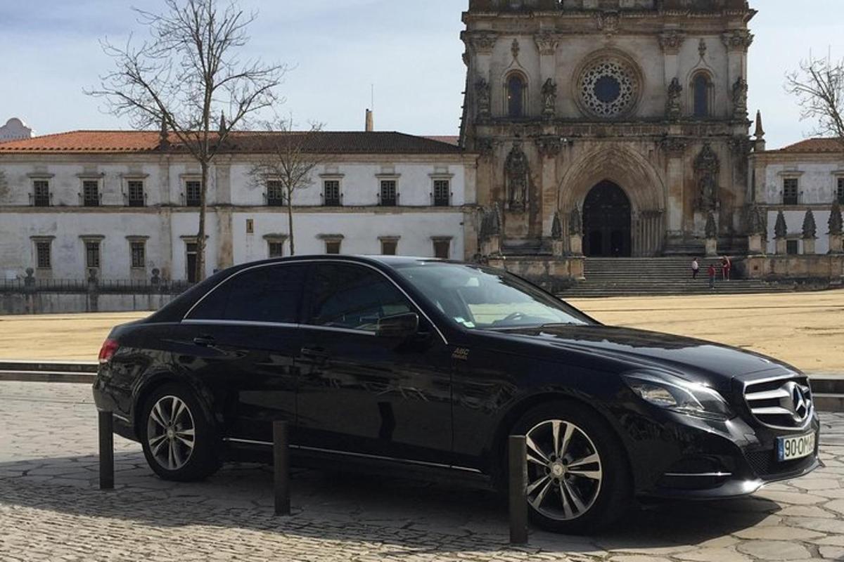um carro preto estacionado em frente a um prédio