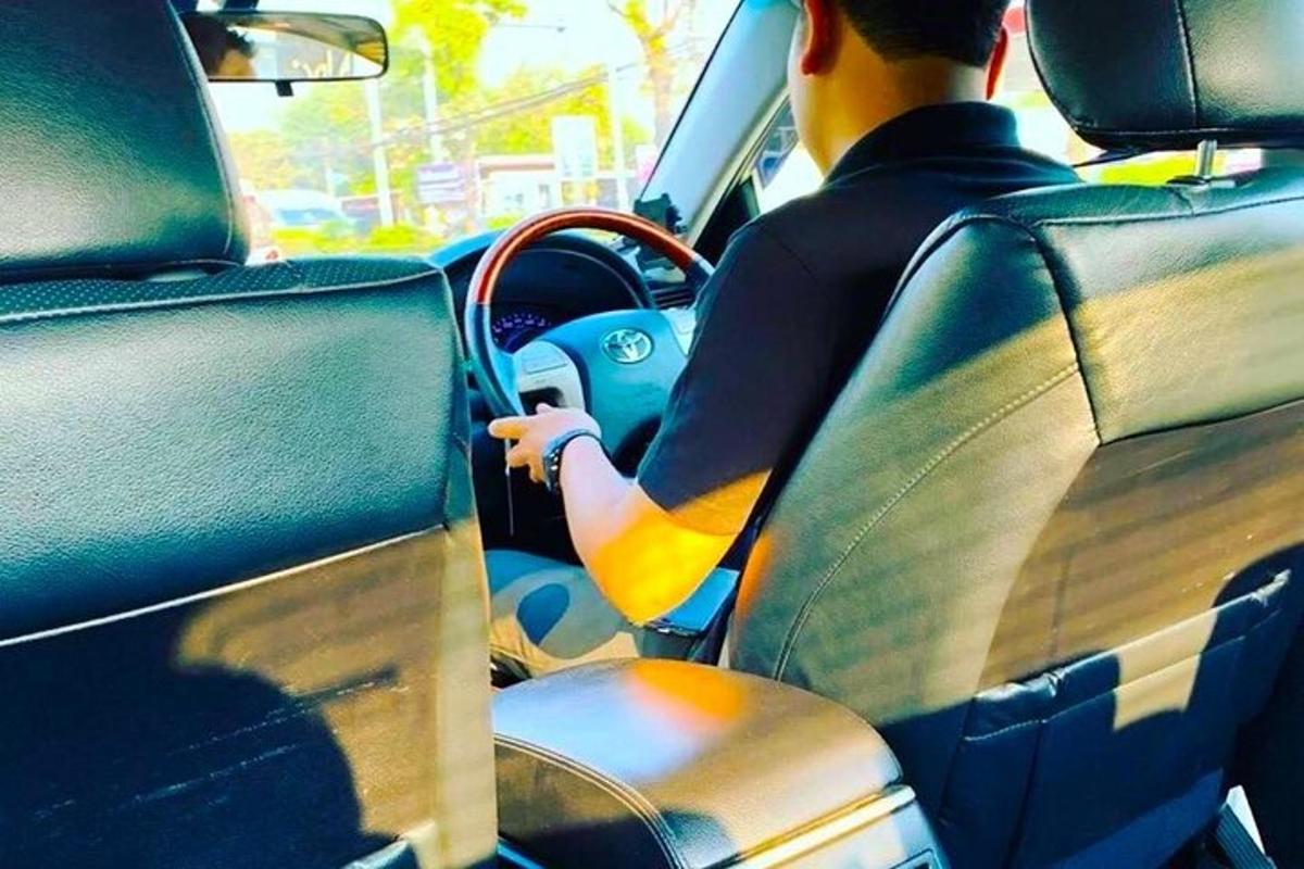 mies istuu autossa
