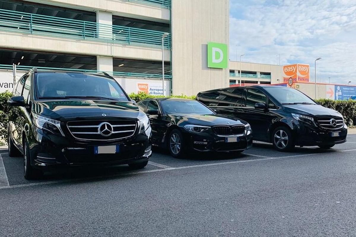 tiga buah kereta diletakkan di tempat letak kereta di hadapan sebuah bangunan
