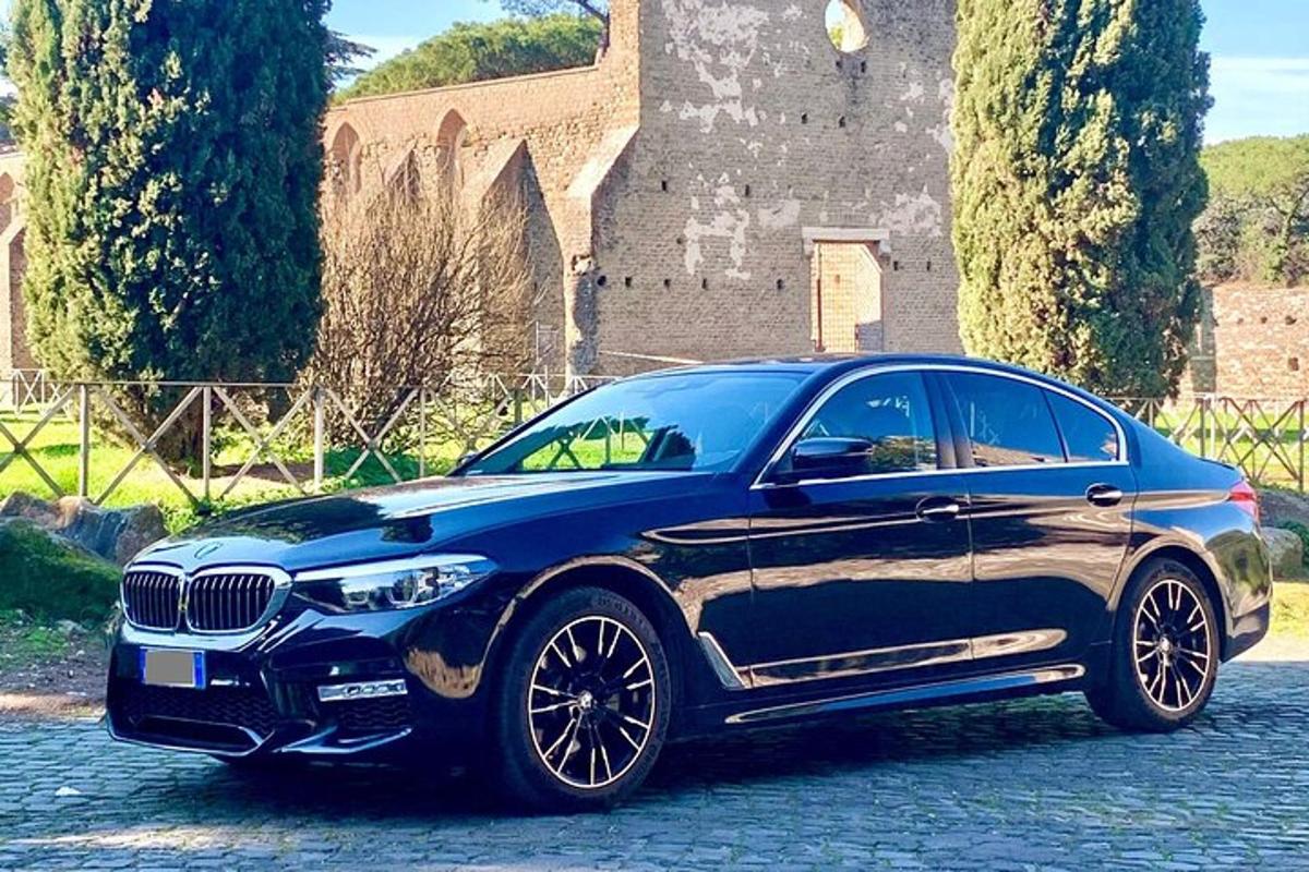 um carro BMW azul estacionado em frente a um castelo