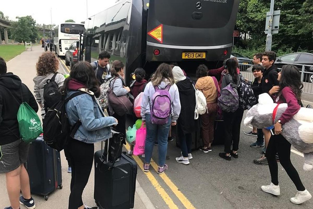 skupina lidí čekajících na nástup do autobusu