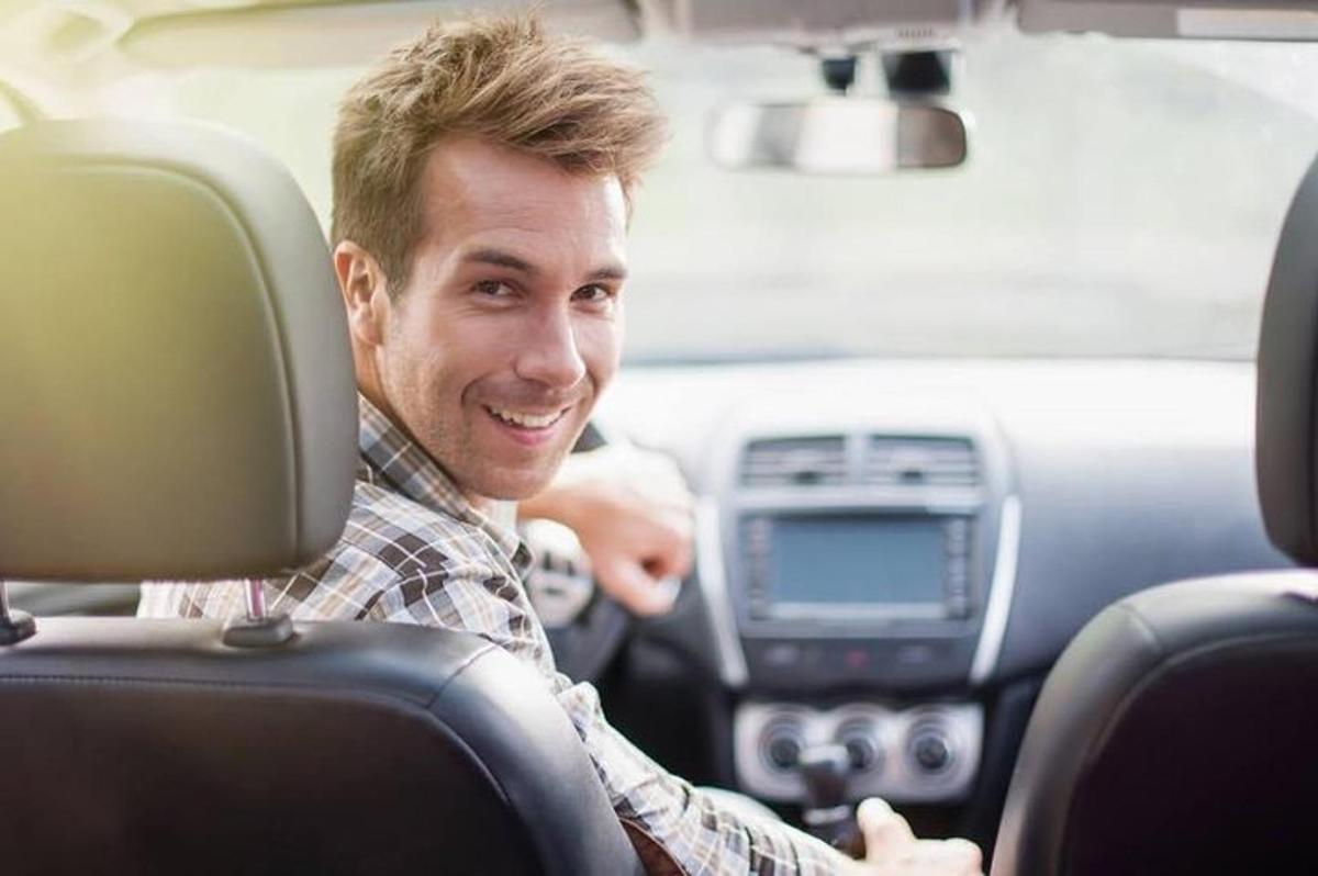 isang lalaking nakaupo sa driver seat ng isang kotse