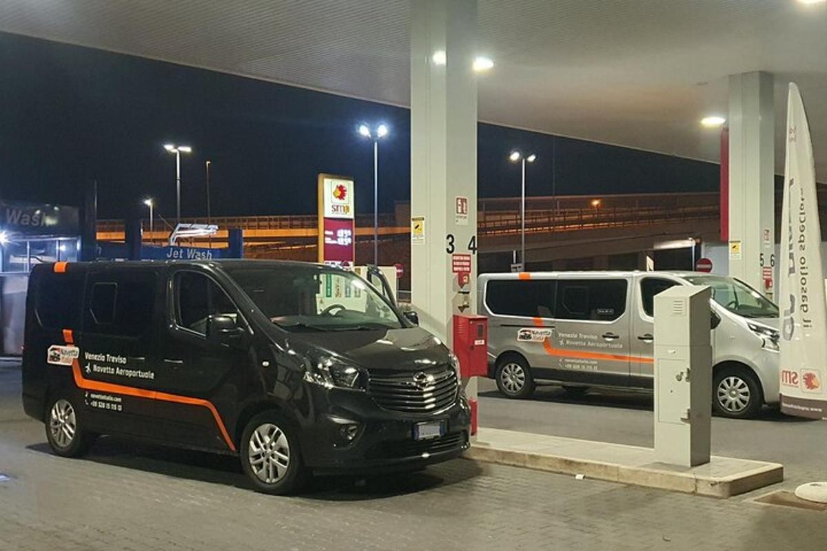 Černá dodávka zaparkovaná v noci u čerpací stanice