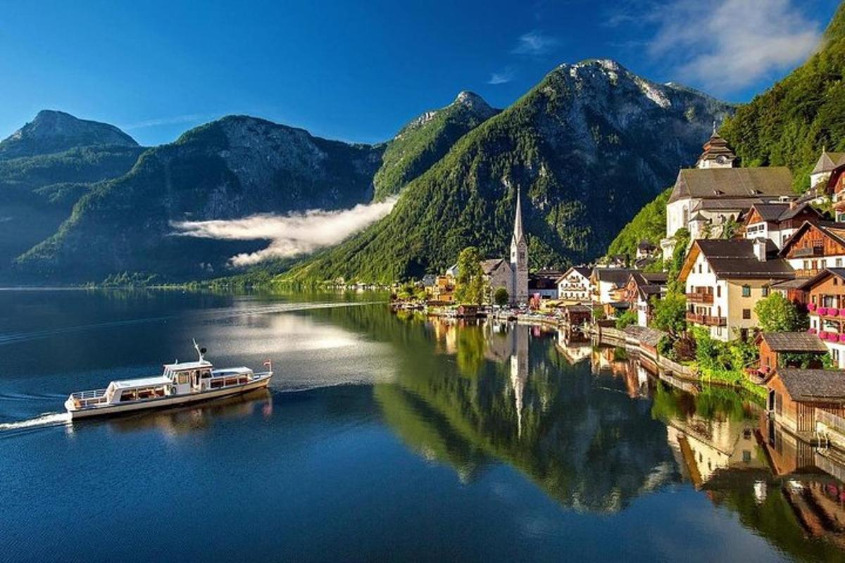 uma pequena cidade às margens de um rio com montanhas ao fundo