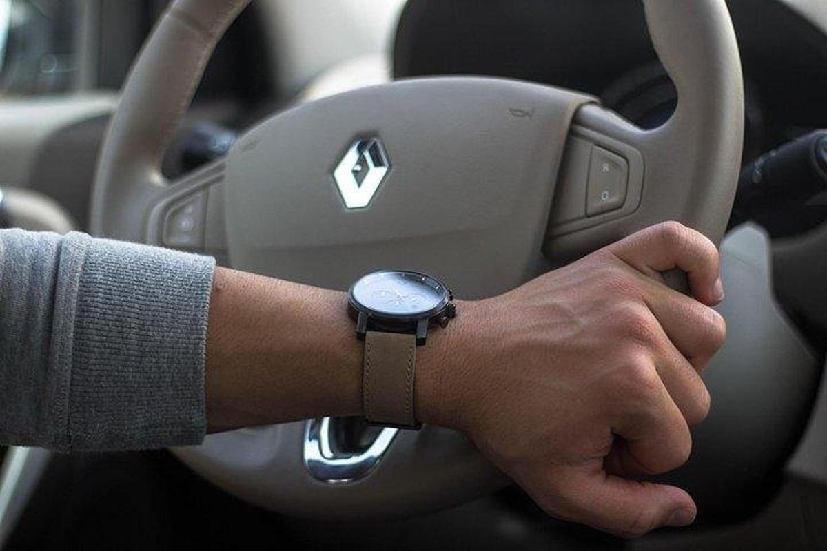 a man is driving a car with a watch on his arm