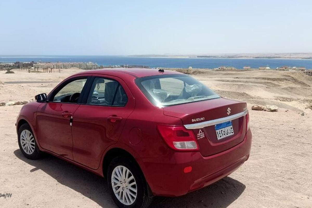 sebuah kereta merah diletakkan di atas pasir berhampiran lautan