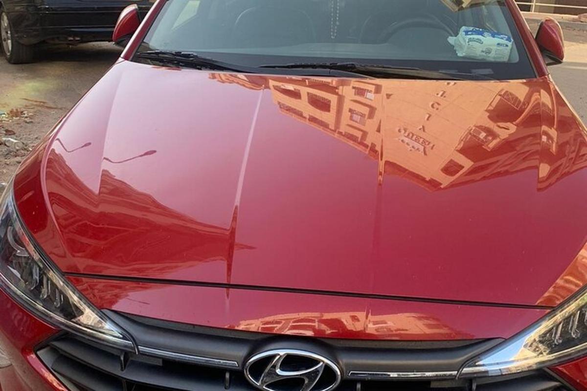 automašīna ar ēkas atspulgu uz motora pārsega