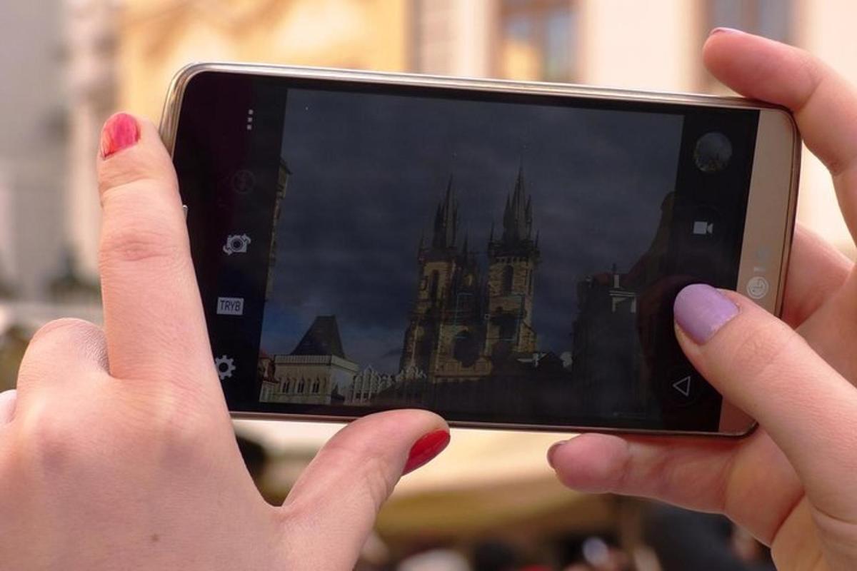 una persona che scatta una foto di un castello con un cellulare