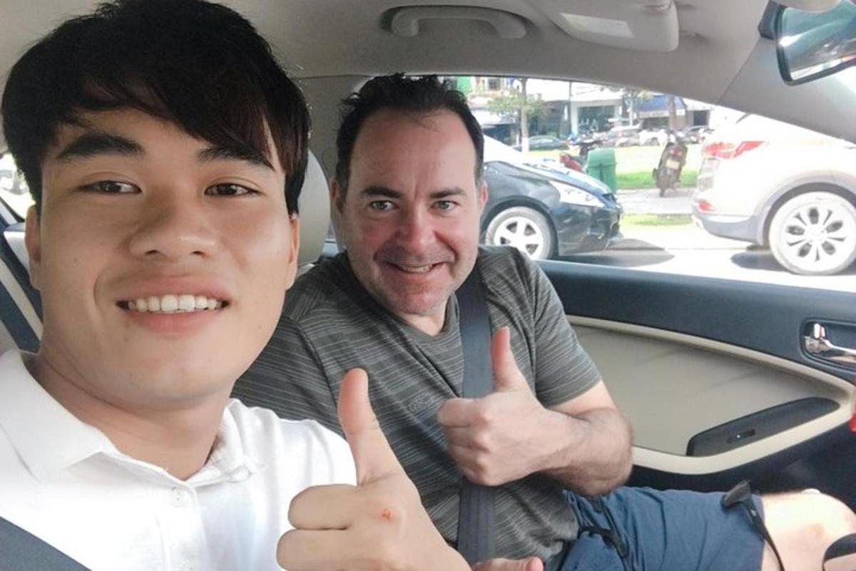 two men sitting in a car giving thumbs up