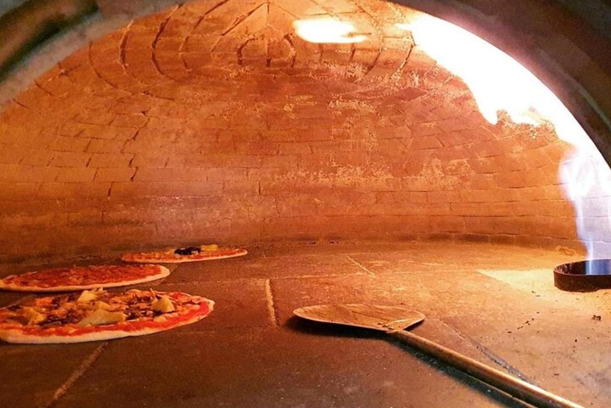 um forno de pizza com três pizzas dentro