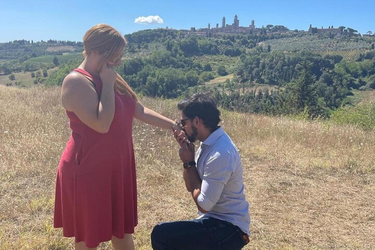 uma mulher de vestido vermelho tirando uma foto de um homem