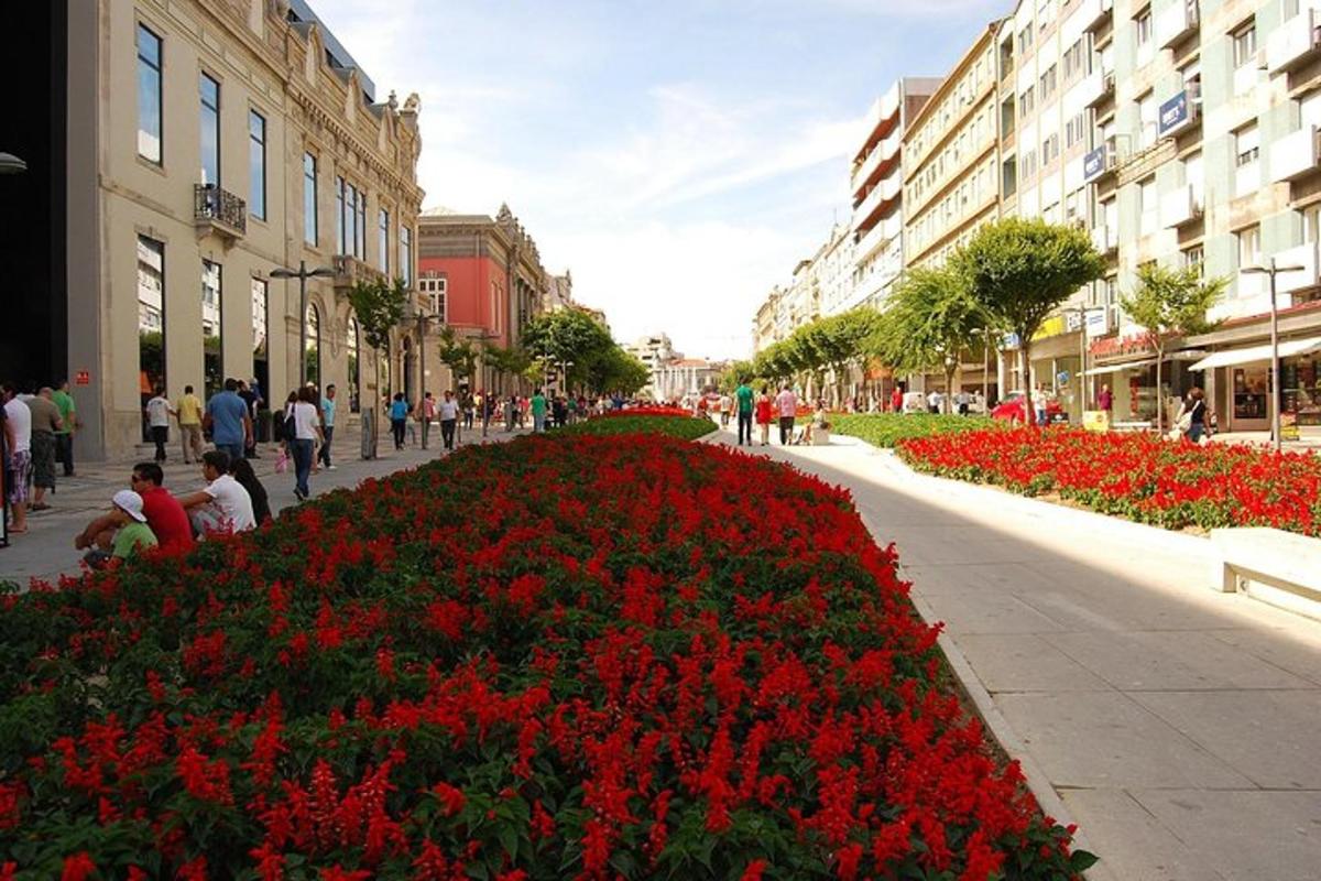 una strada con fiori rossi in una città con edifici