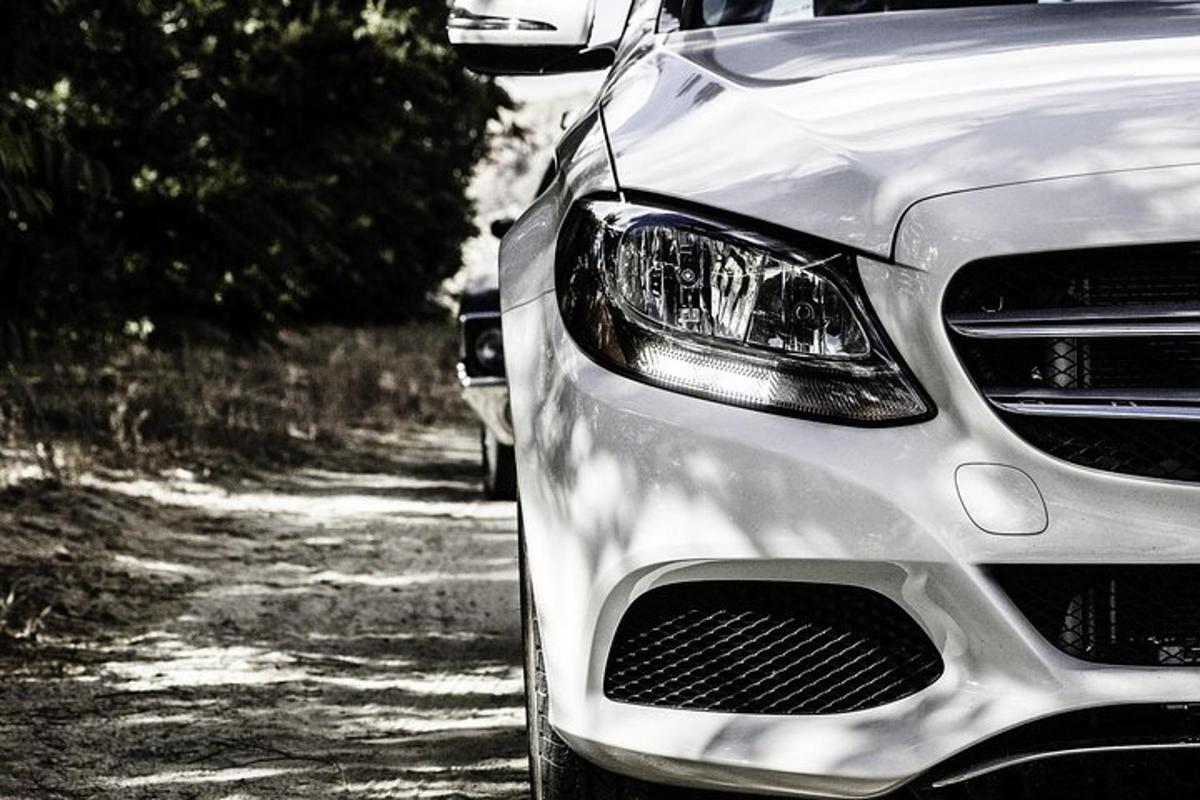stříbrné auto zaparkované na prašné cestě