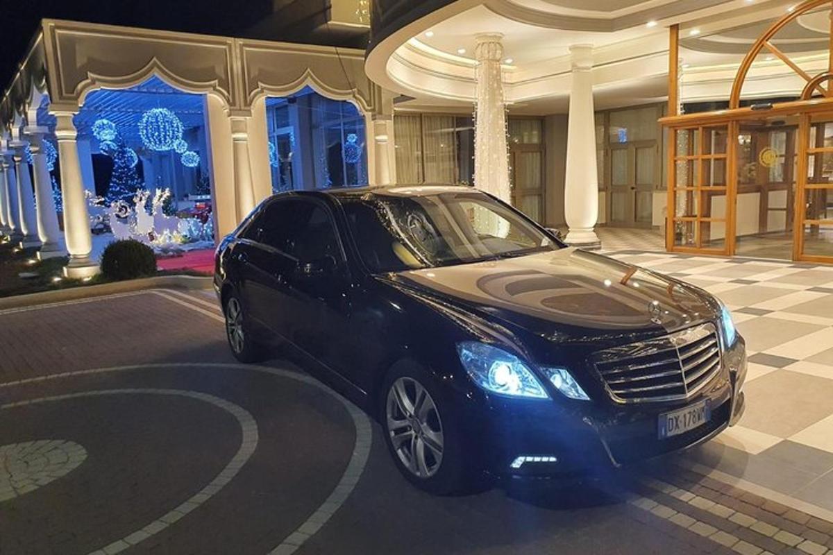 um carro preto estacionado em frente a um prédio