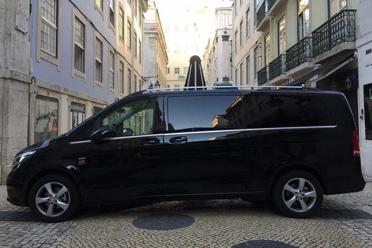 uma van preta estacionada na rua com um guarda-chuva