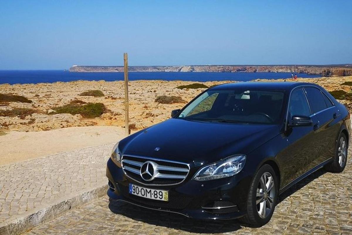 un'auto Mercedes Benz blu parcheggiata accanto a una spiaggia
