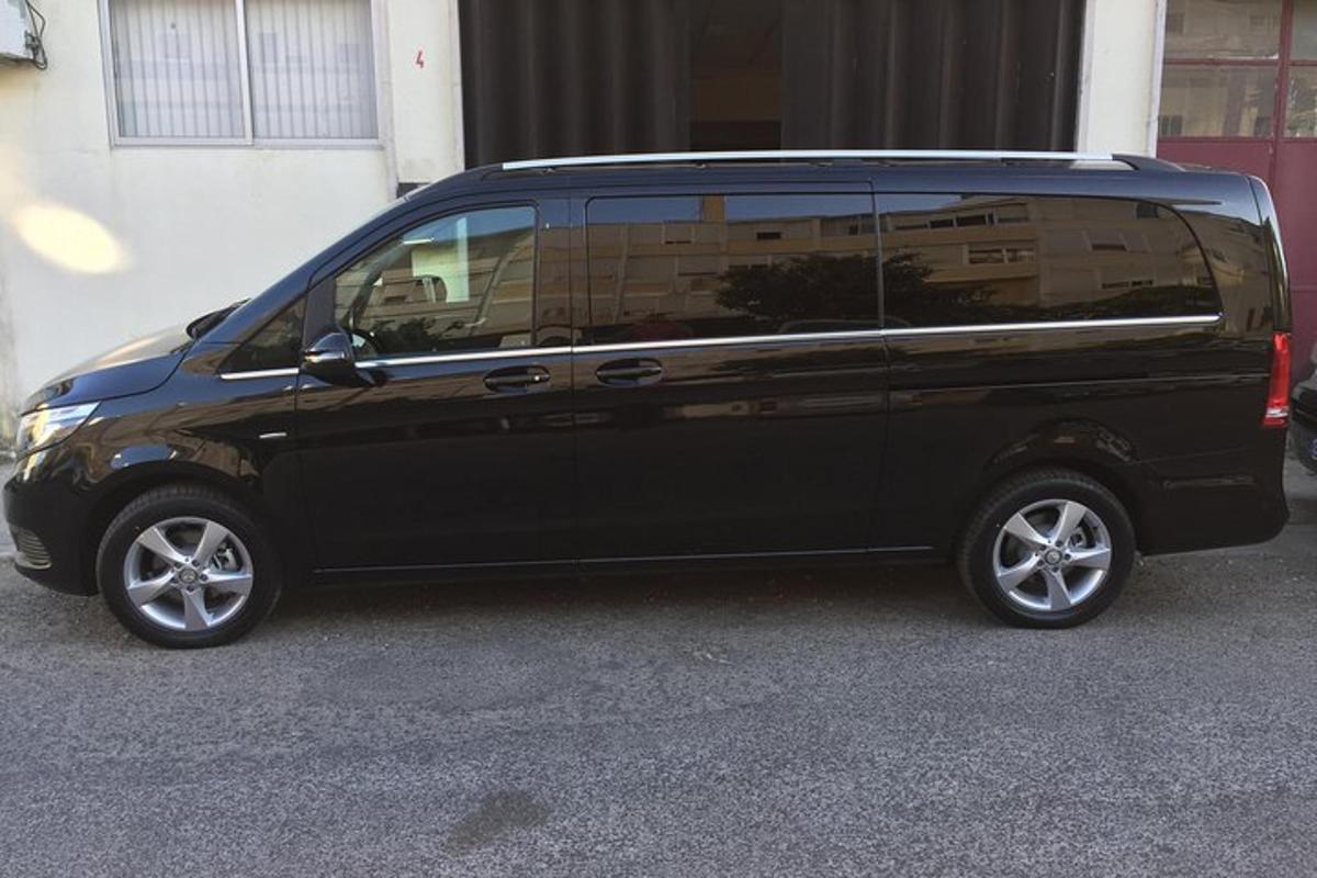 sebuah mobil van hitam diparkir di depan sebuah gedung