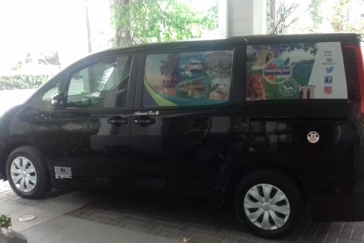 Una camioneta negra estacionada en una calle con un cartel al costado