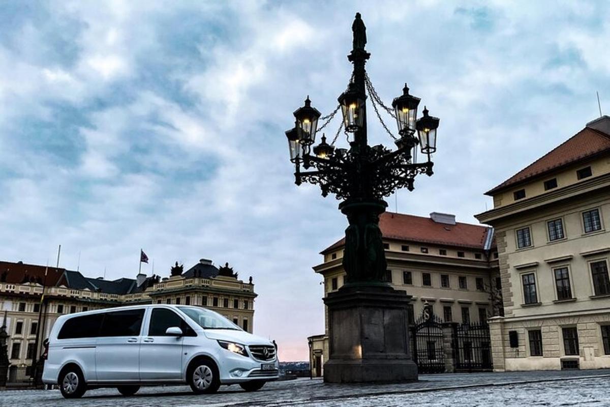 biela dodávka zaparkovaná vedľa stĺpa verejného osvetlenia