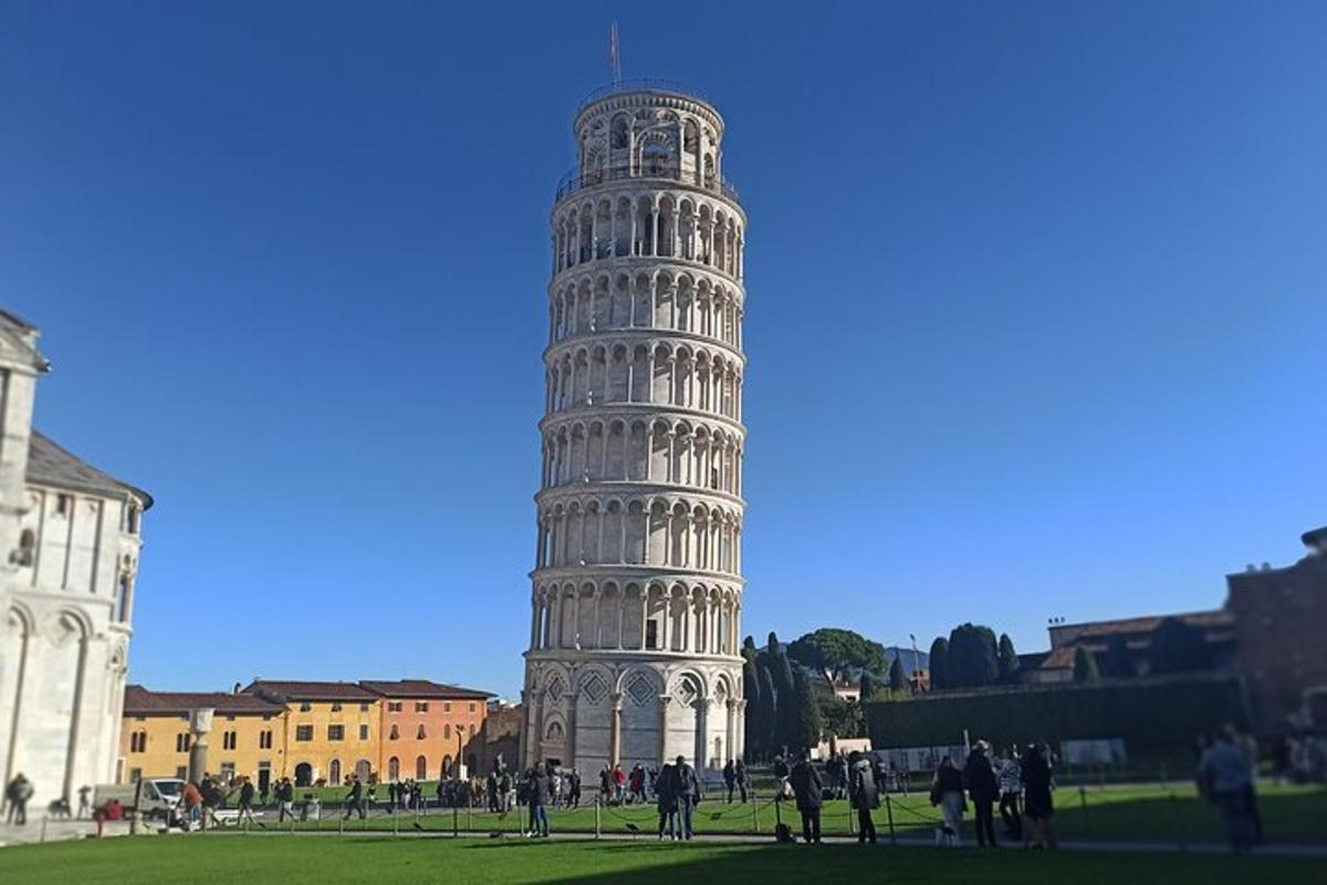 uma torre inclinada com pessoas em pé ao redor dela