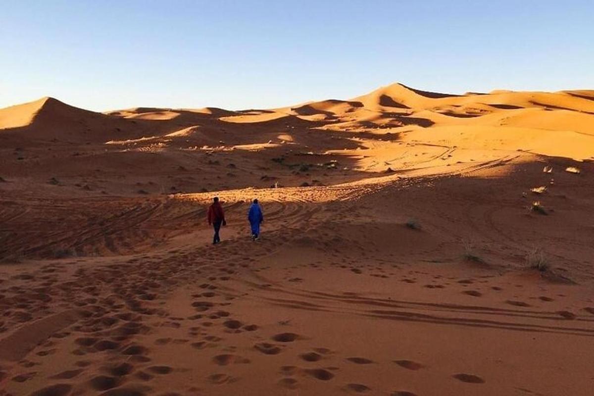 شخصان يسيران على طريق ترابي في الصحراء