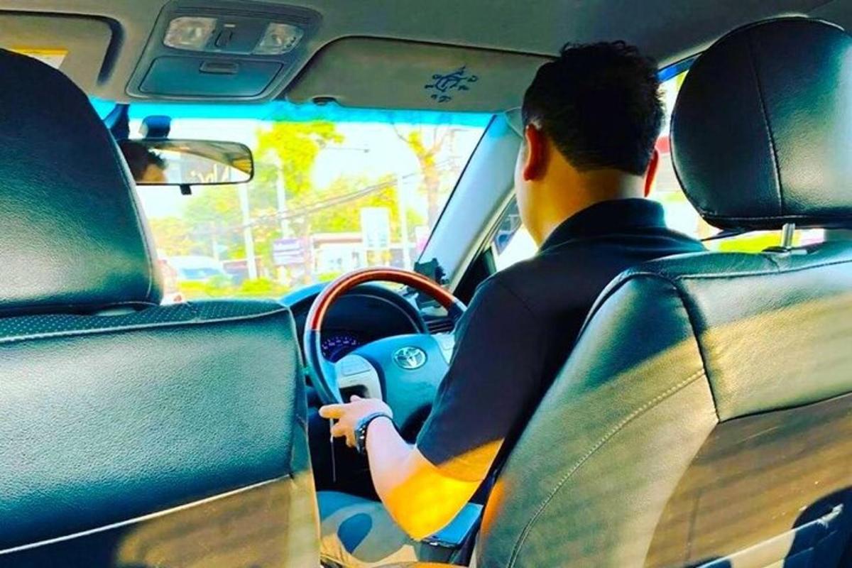 un bărbat care conduce o mașină cu o placă de surf pe bord