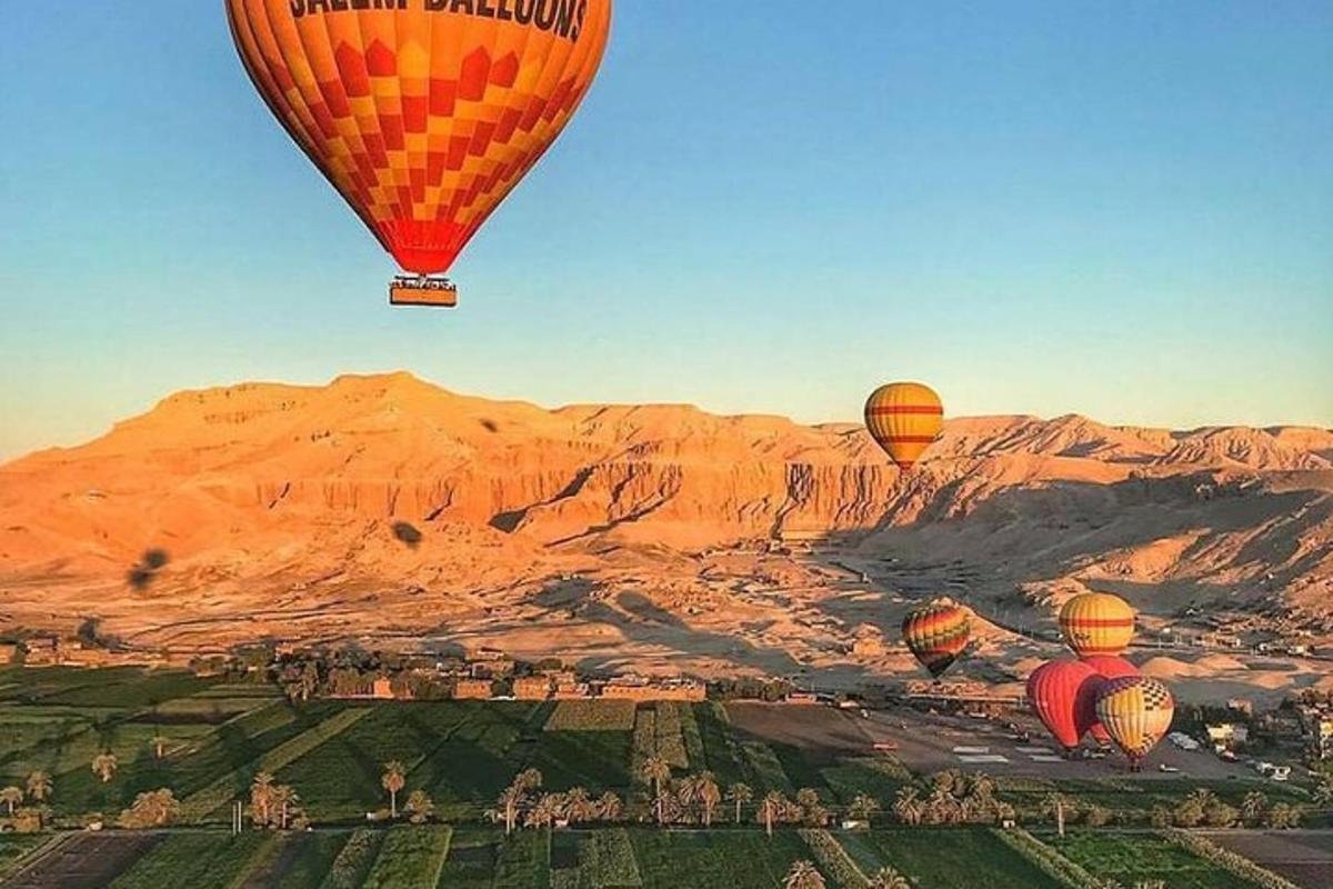 Skupina horkovzdušných balónů letících nad pouští