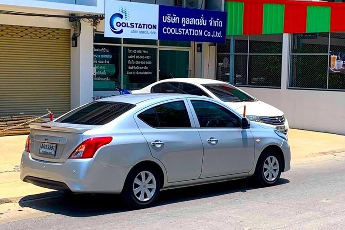 Un coche plateado aparcado delante de una tienda.