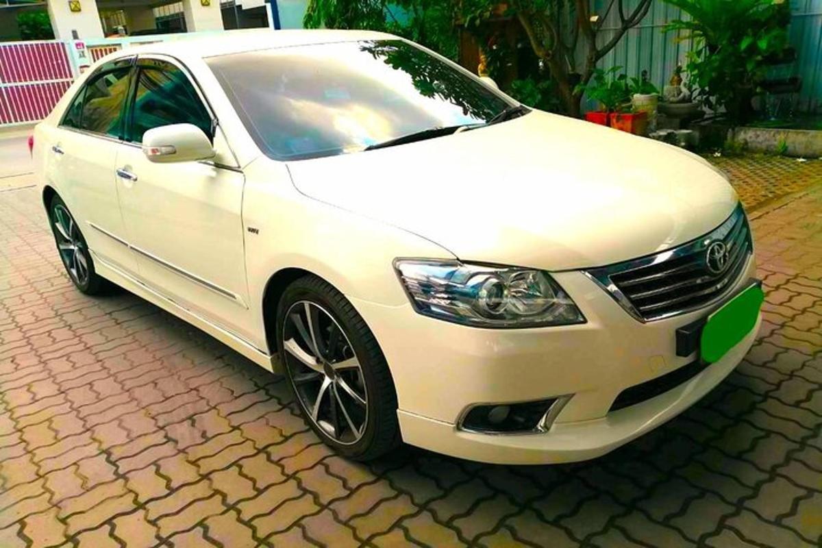bílé auto zaparkované na cihlové silnici