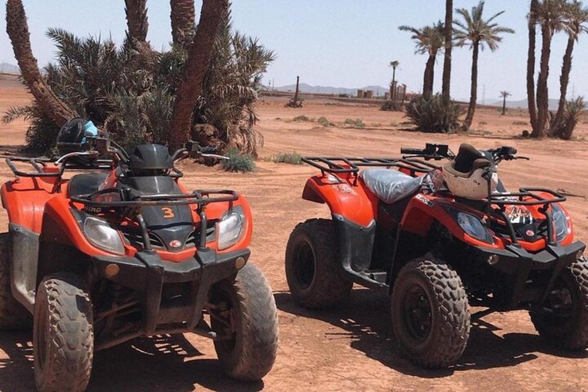 two atvs and a four wheeler parked in the desert