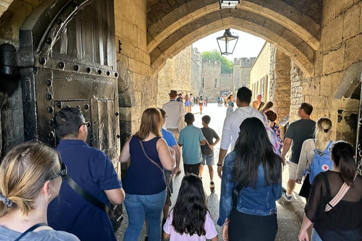 una folla di persone che camminano sotto un arco