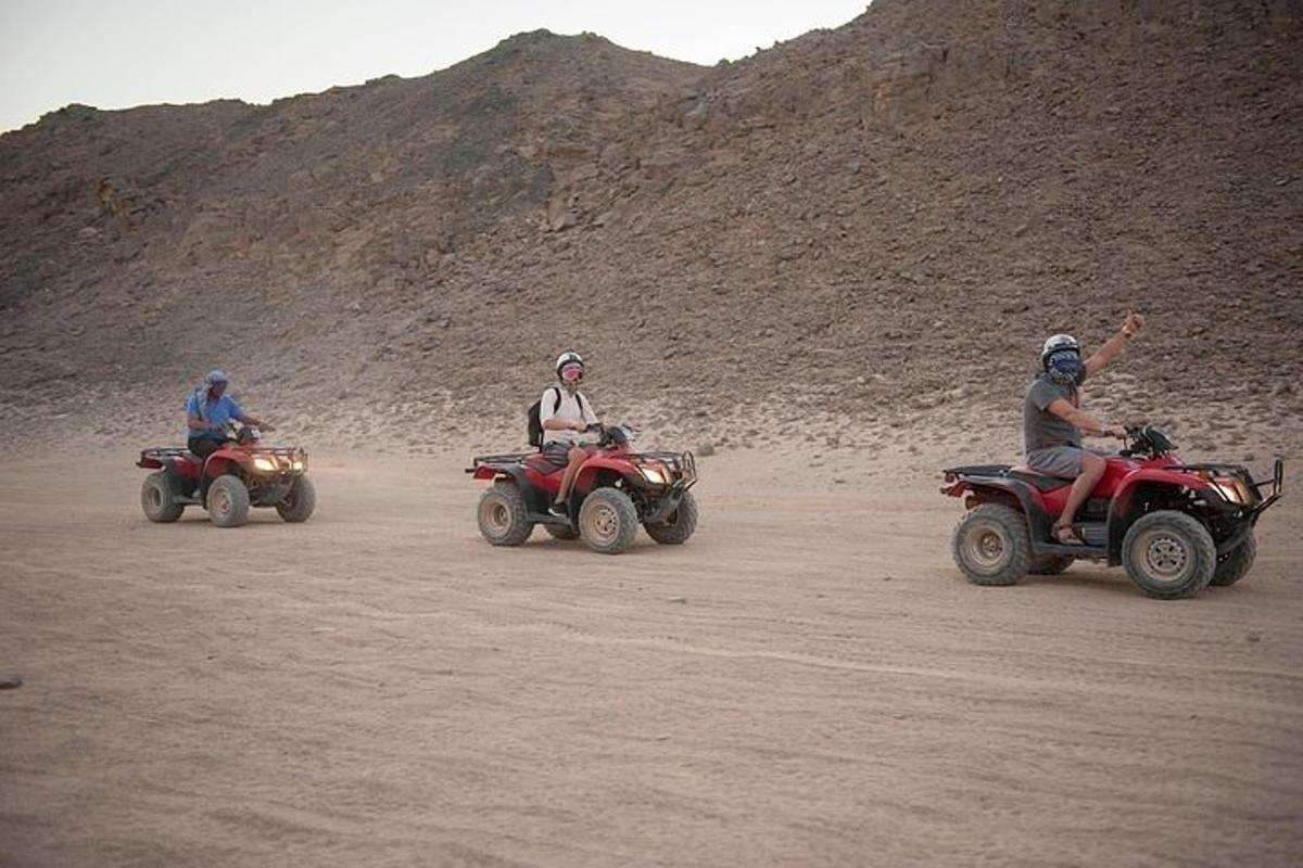 未舗装道路を走るATVに乗った3人