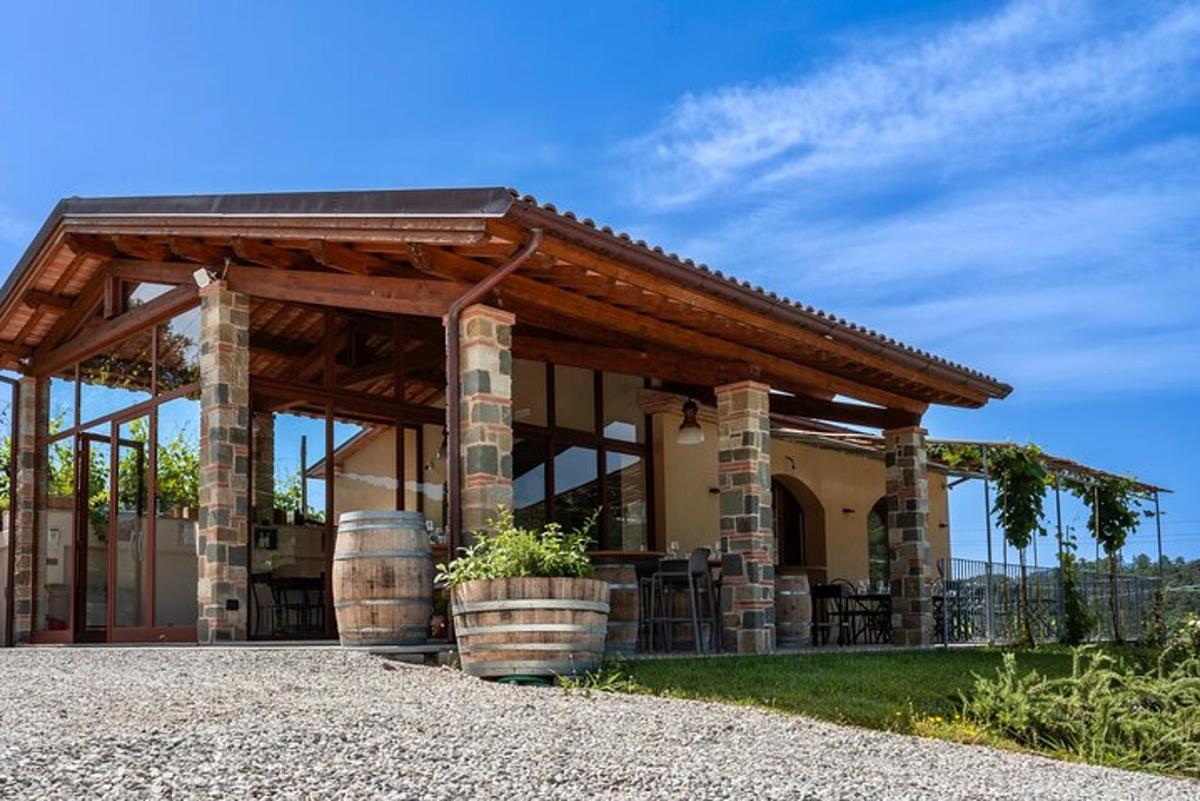 a house with a pavilion with barrels in front of it