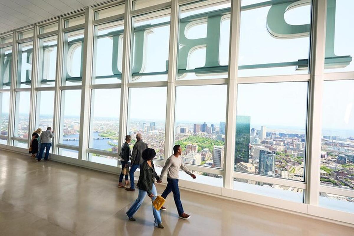 a group of people walking in a building with large windows