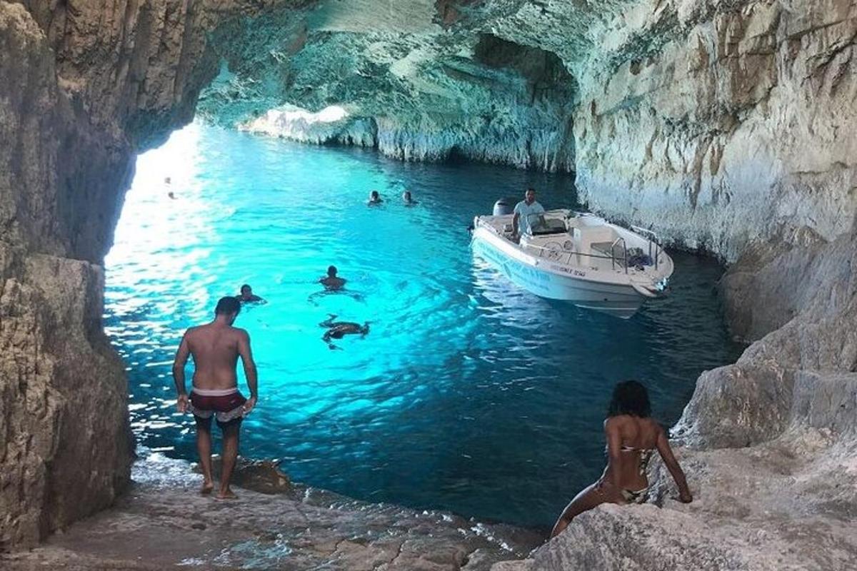 a group of people in a cave with a boat in the water