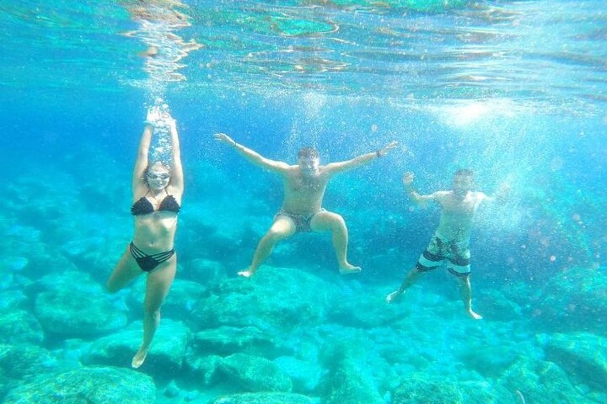 three people swimming in the water in the ocean