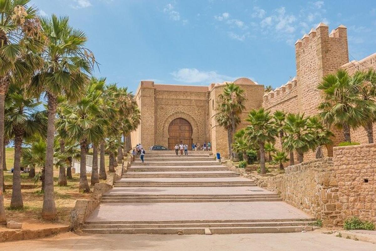 a building with stairs leading up to a building with palm trees
