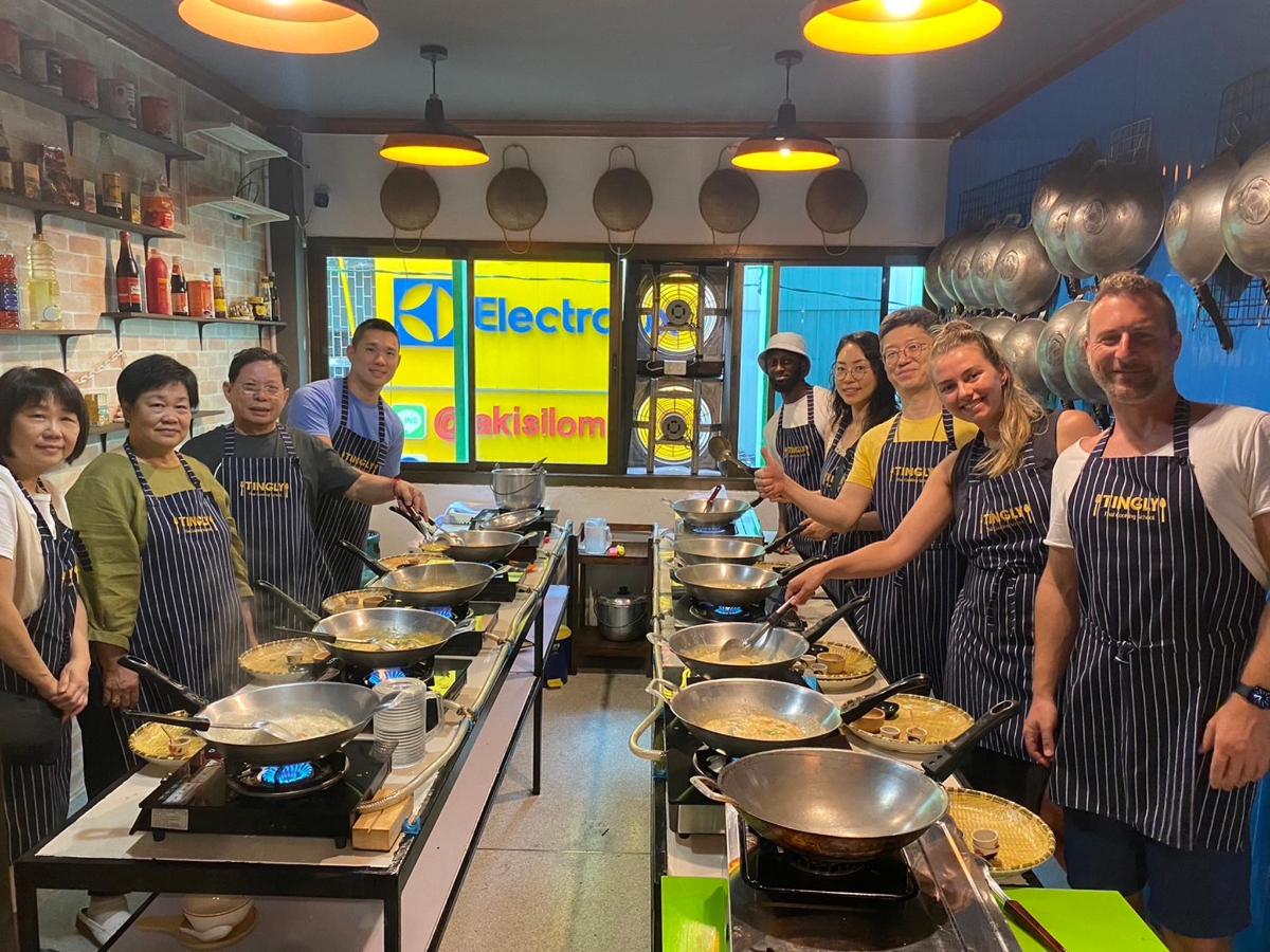 a group of people standing in a kitchen preparing food
