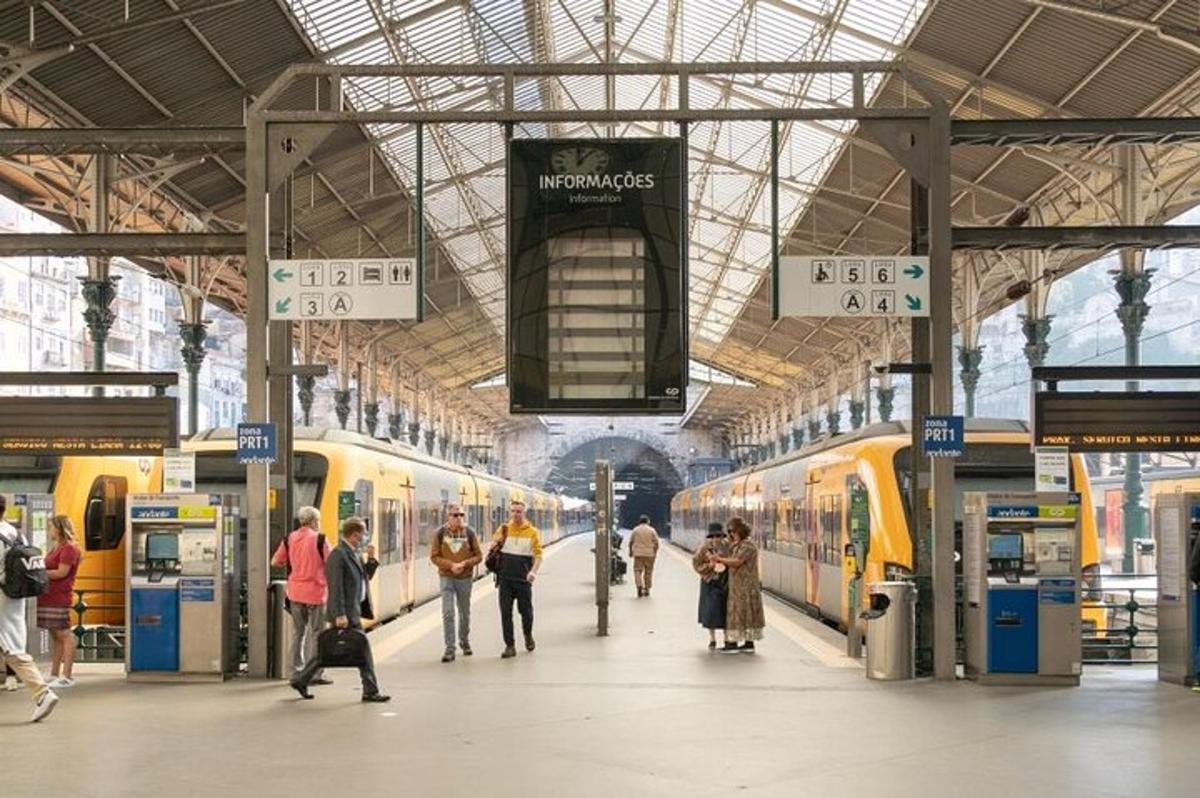 ein Bahnhof mit Menschen, die zwischen zwei Zügen gehen