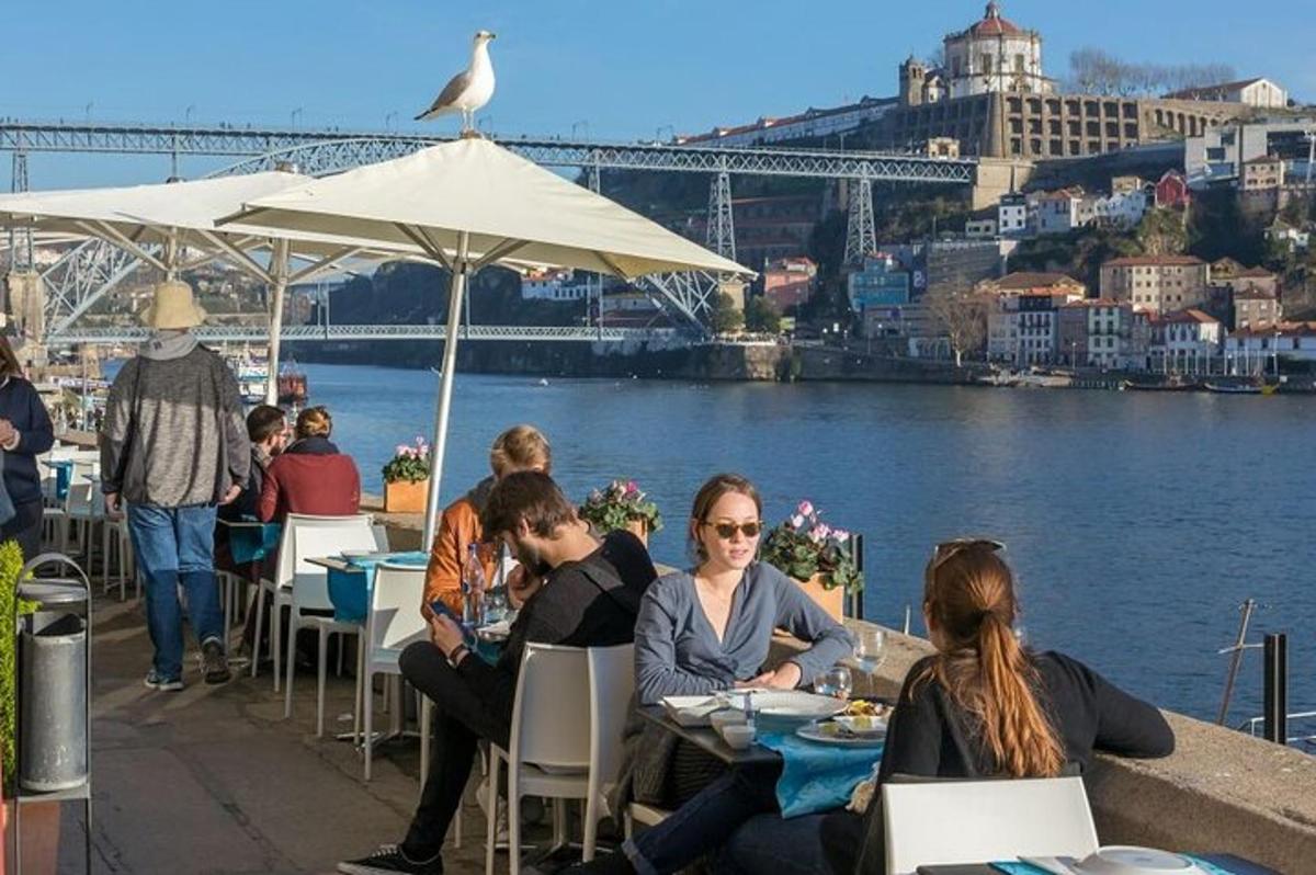 grupa ljudi koji sjede za stolovima blizu vode