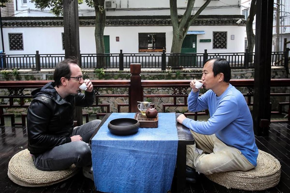 two men sitting at a table eating food