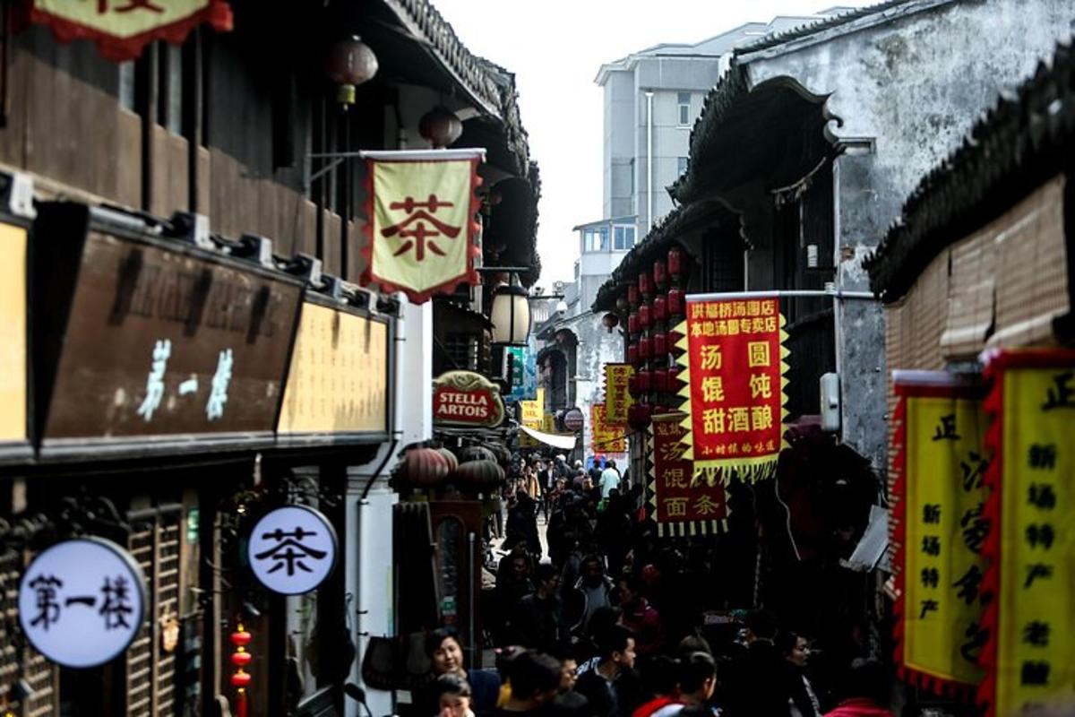 a crowd of people walking down a street with signs