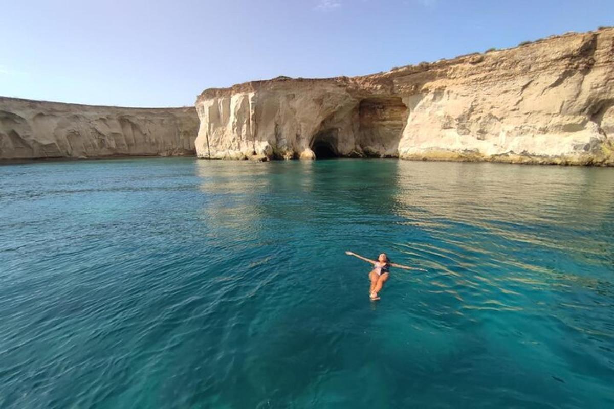 une personne nageant dans l'eau près d'une grotte