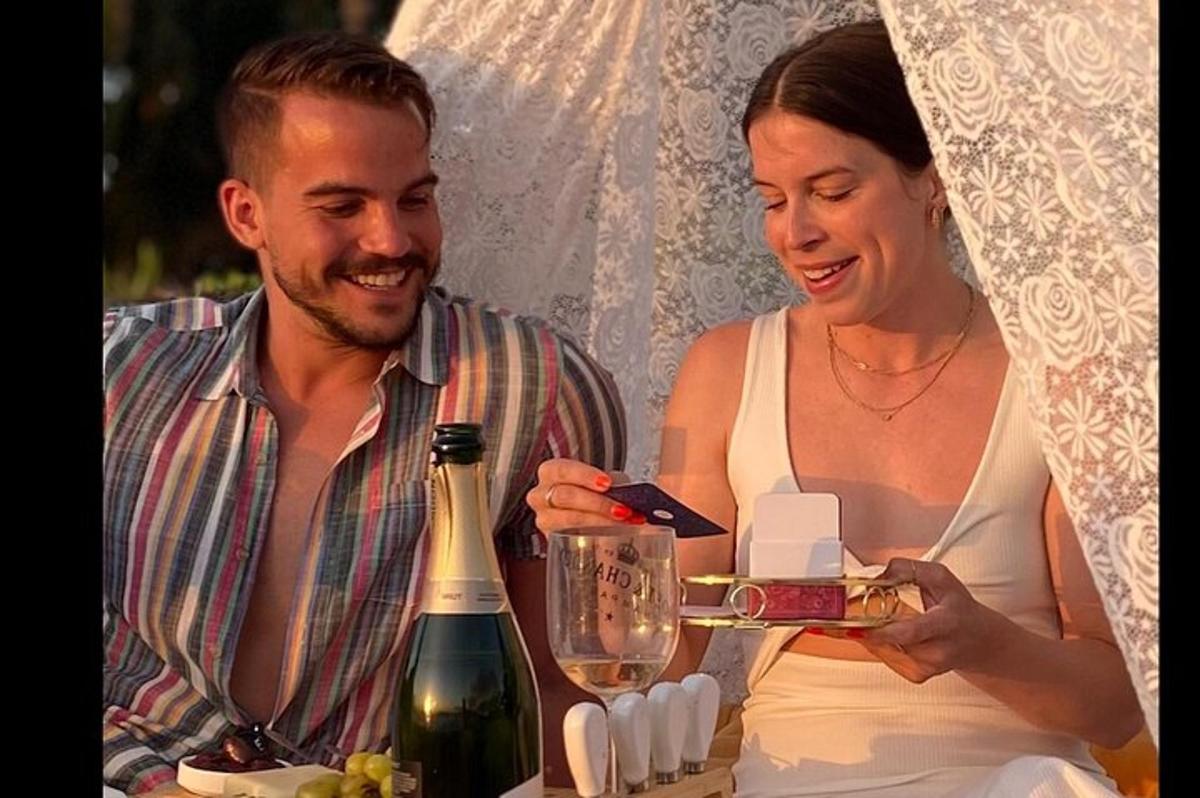 un uomo e una donna che guardano una bottiglia di vino