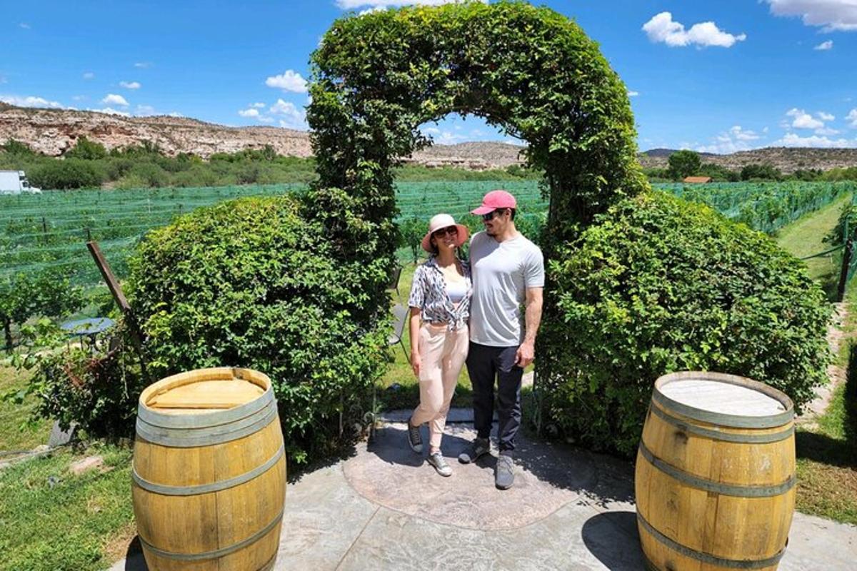 Un hombre y una mujer de pie frente a dos barriles.