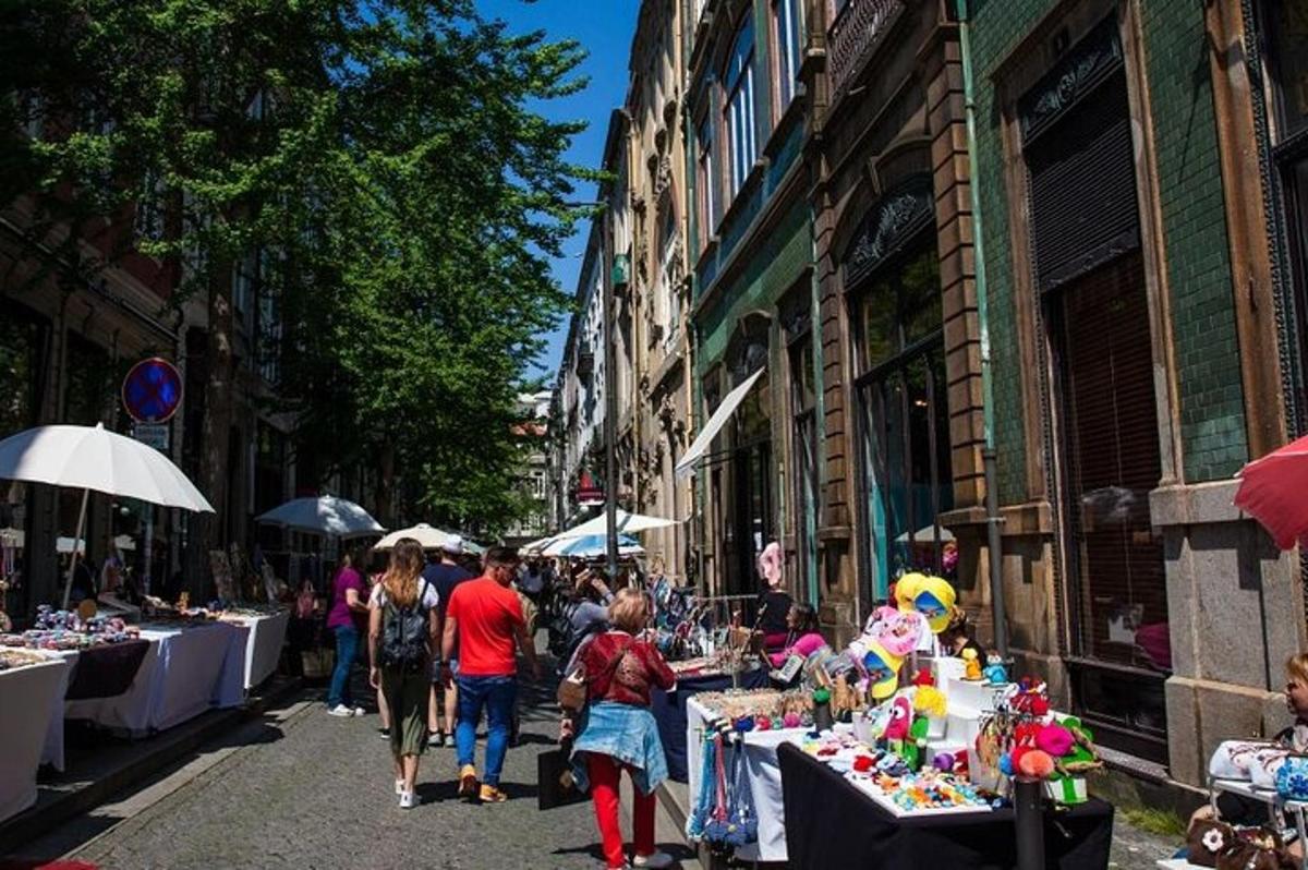 un groupe de personnes marchant dans une rue avec des tables